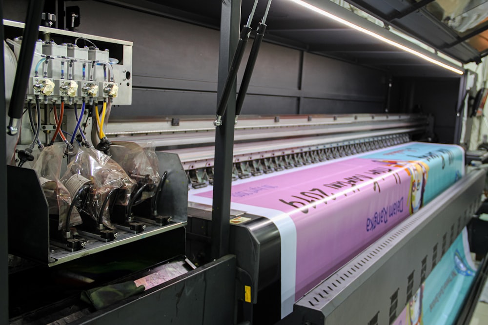 A wide format printer running a large magenta print